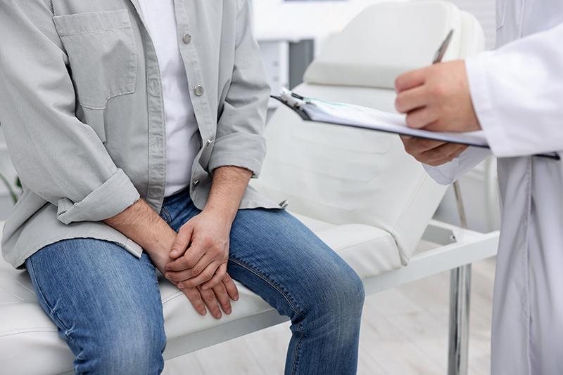 Man preparing for a physical examination during a urology consultation with a specialist.
